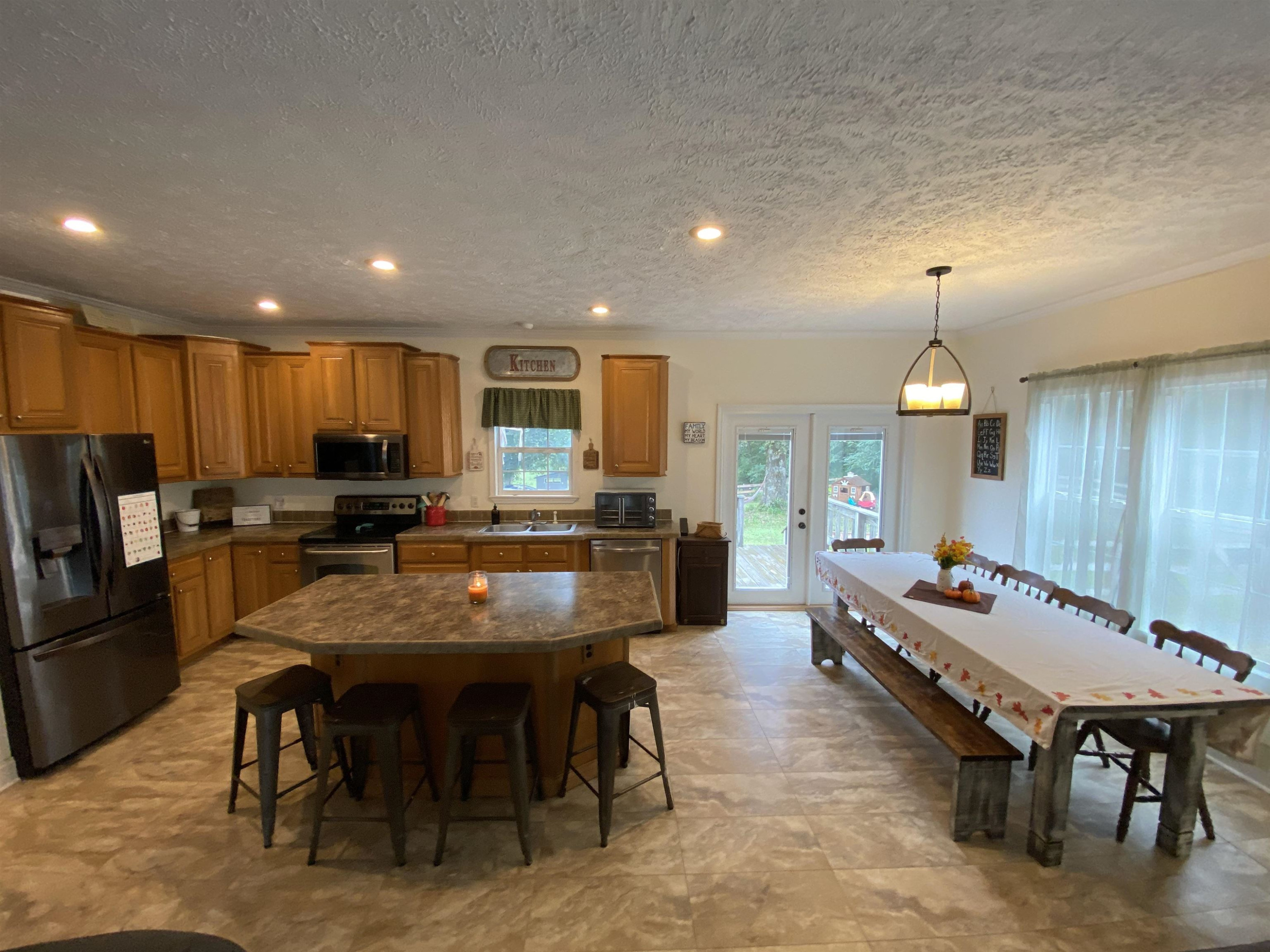 3070 Westport Road Huntingdon, TN 38344 - Photo 5 of 23 a kitchen with a dining table chairs refrigerator and microwave