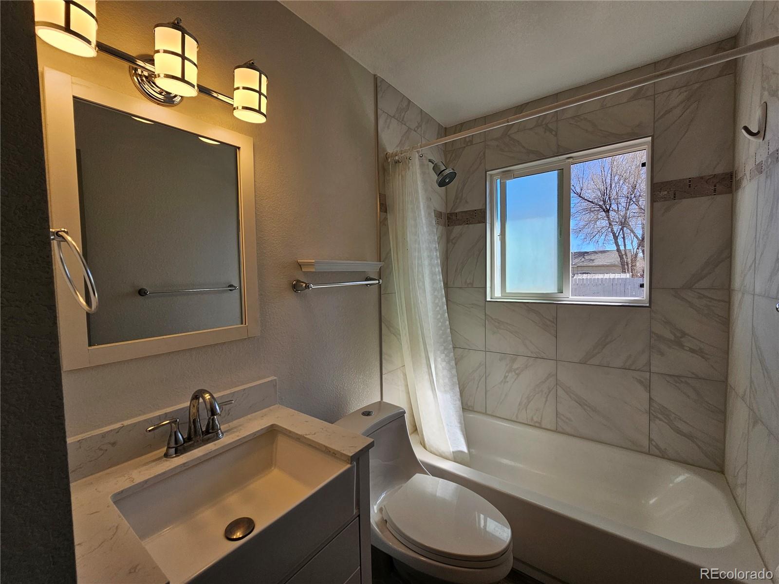 1723 Ascot Road Colorado Springs, CO 80906 - Photo 12 of 29 a bathroom with a sink mirror vanity and toilet
