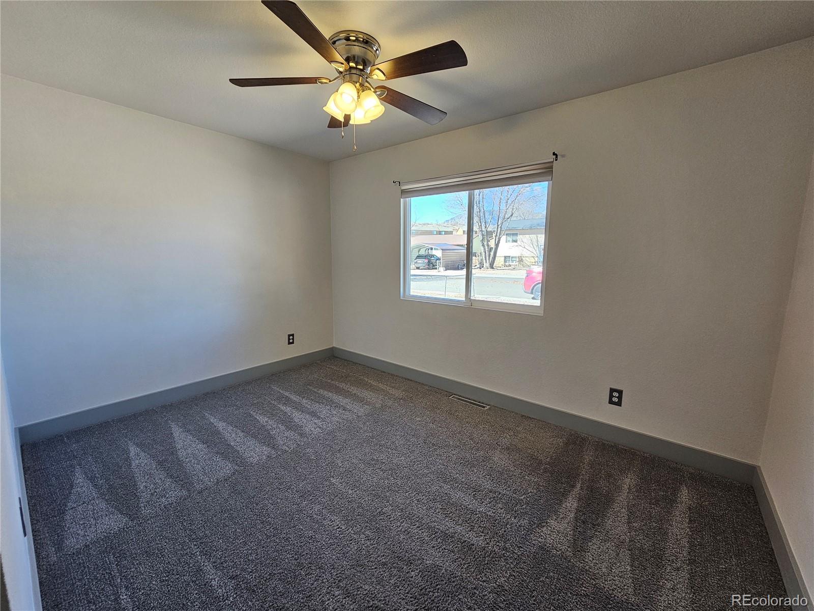 1723 Ascot Road Colorado Springs, CO 80906 - Photo 13 of 29 an empty room with windows and fan