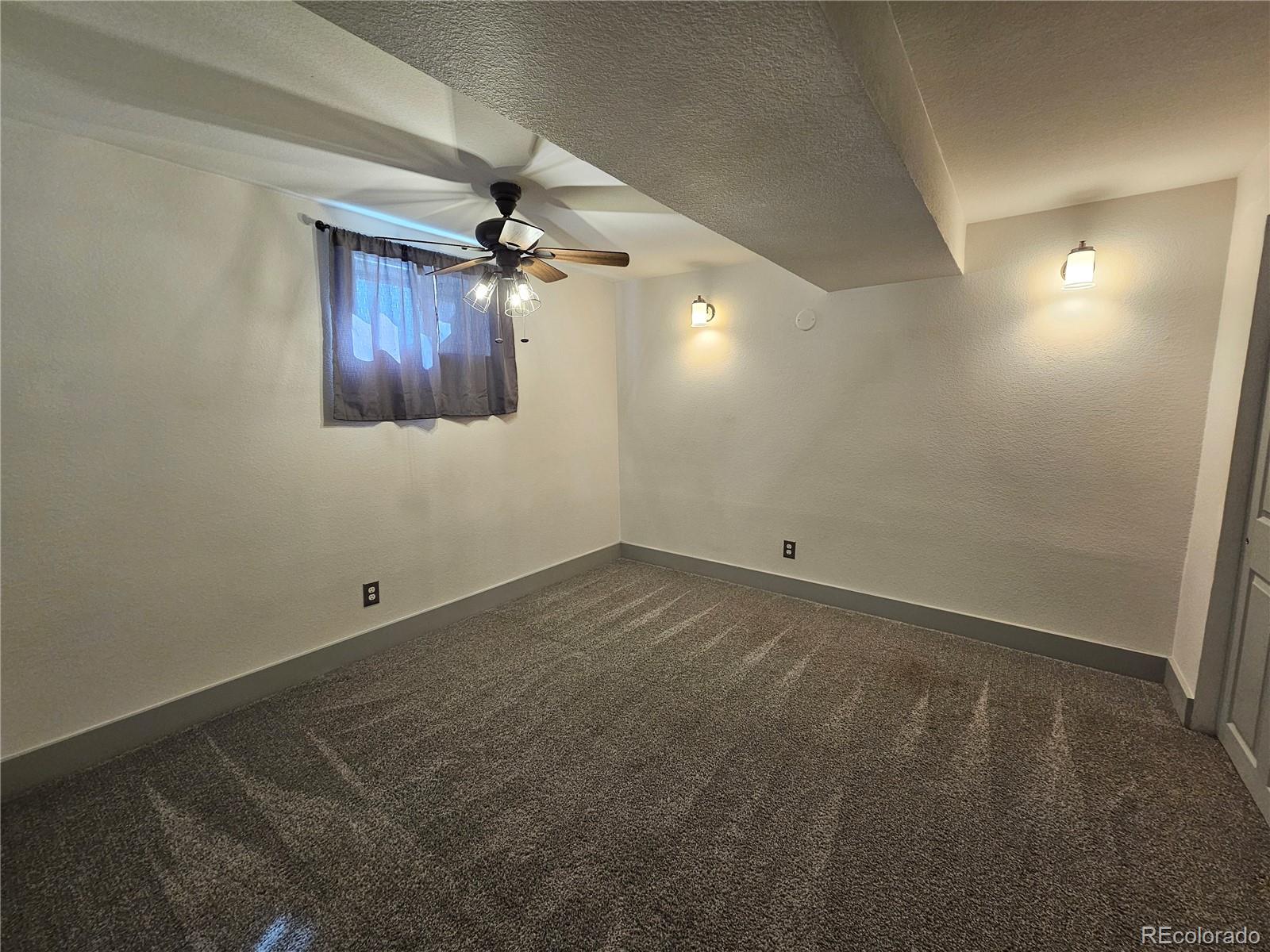 1723 Ascot Road Colorado Springs, CO 80906 - Photo 20 of 29 an empty room with a ceiling fan and windows