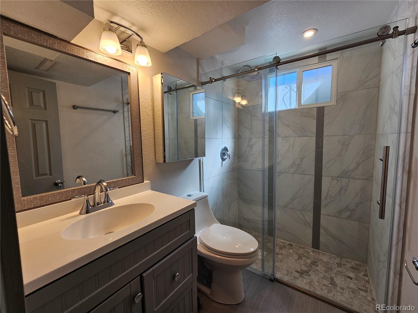 1723 Ascot Road Colorado Springs, CO 80906 - Photo 22 of 29 a bathroom with a sink a toilet and shower