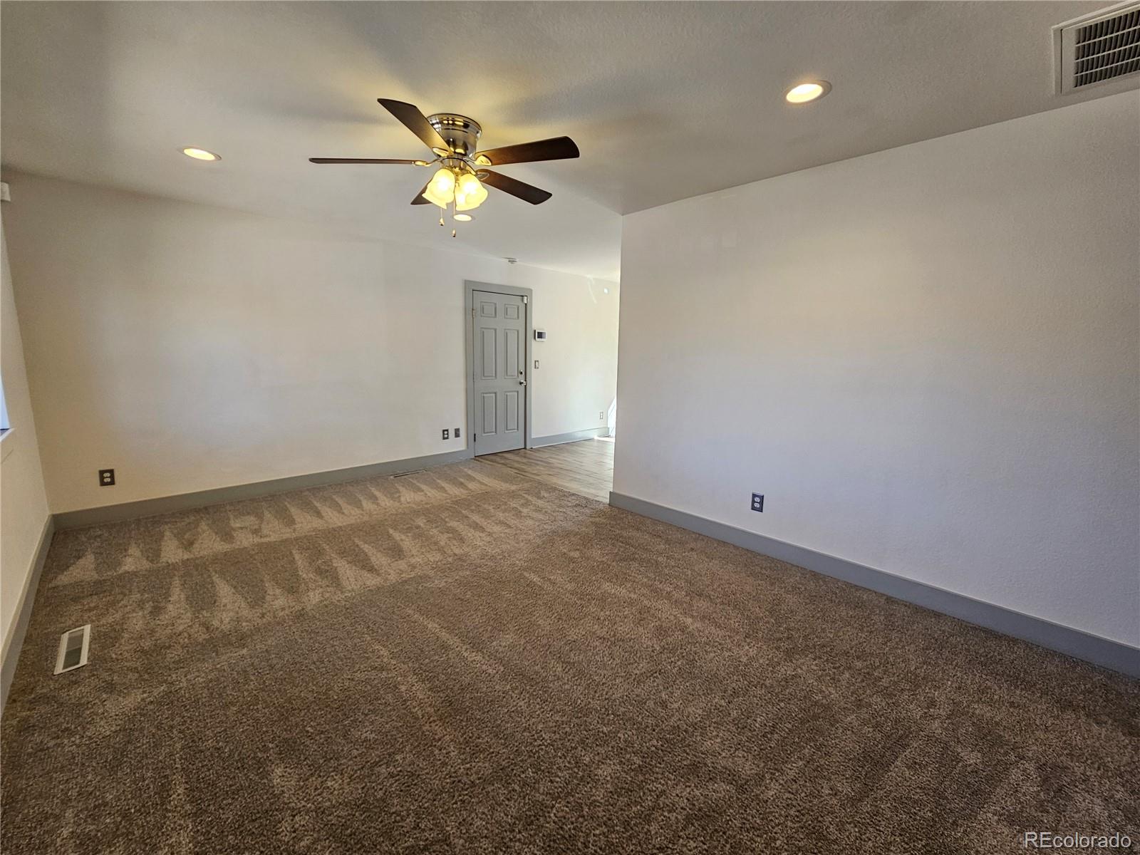 1723 Ascot Road Colorado Springs, CO 80906 - Photo 3 of 29 an empty room with a ceiling fan and a window