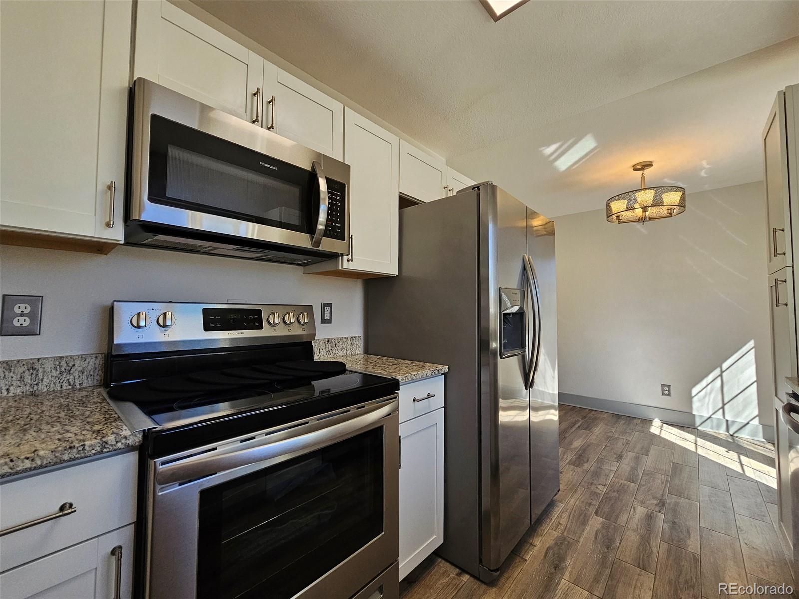 1723 Ascot Road Colorado Springs, CO 80906 - Photo 9 of 29 a kitchen with stainless steel appliances granite countertop a stove microwave and refrigerator