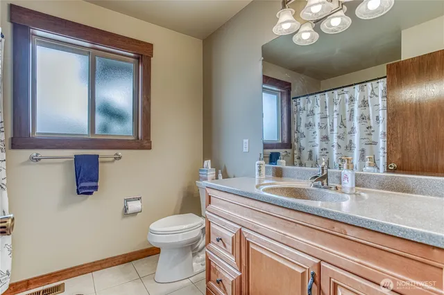a bathroom with a toilet a sink and mirror
