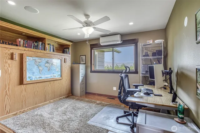 a view of a workspace with furniture and a window