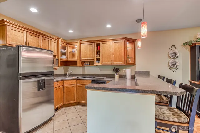 a kitchen with stainless steel appliances granite countertop a sink a stove a refrigerator a microwave oven with white cabinets and wooden floor