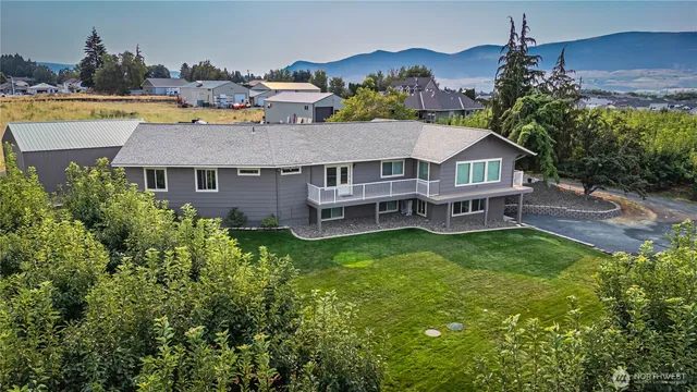 an aerial view of a house with a garden and lake view
