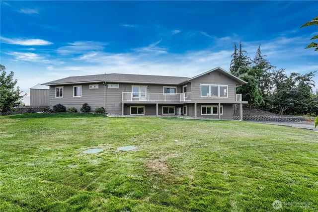 a view of a house with a big yard and large trees