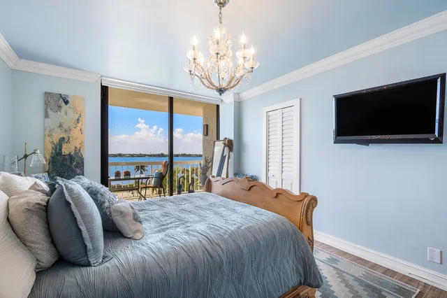 a bedroom with a bed and a flat tv screen on the dresser