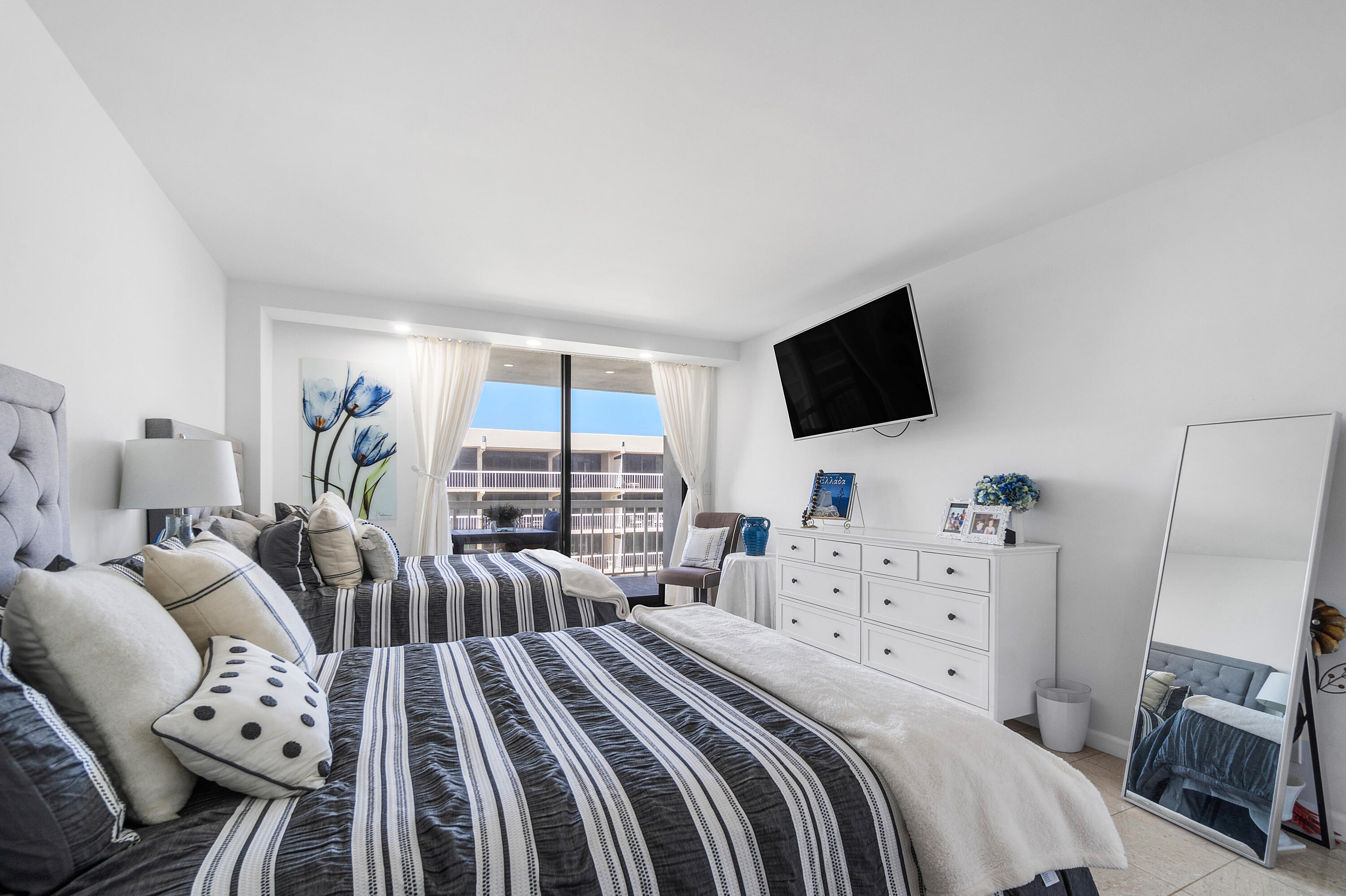 3300 South Ocean Boulevard, Unit 405 Palm Beach, FL 33480 - Photo 16 of 23 a bedroom with two beds and a flat screen tv