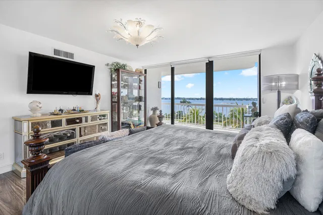 a spacious bedroom with a bed and a flat screen tv