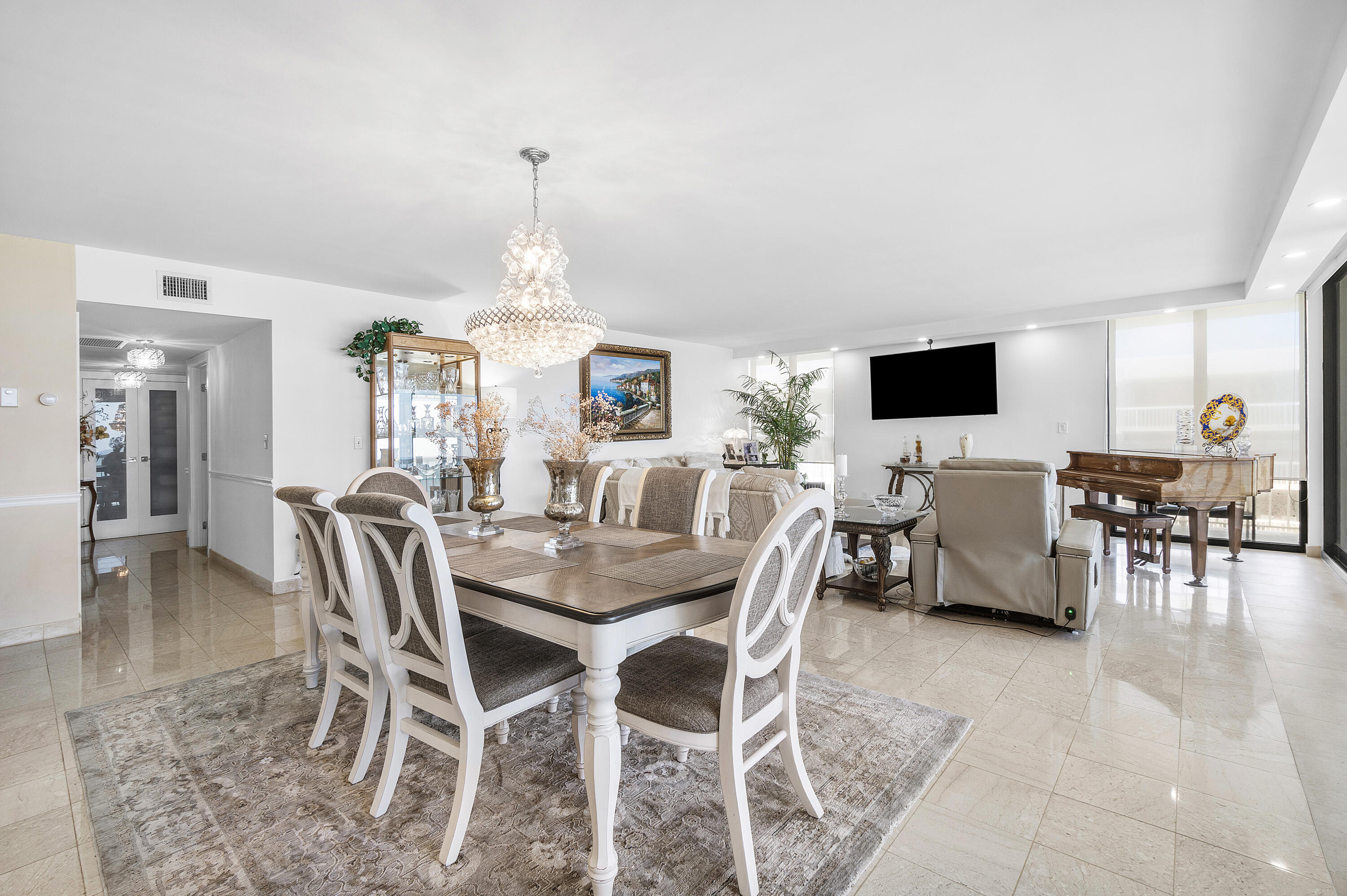 3300 South Ocean Boulevard, Unit 405 Palm Beach, FL 33480 - Photo 10 of 23 a view of a dining room with furniture and chandelier