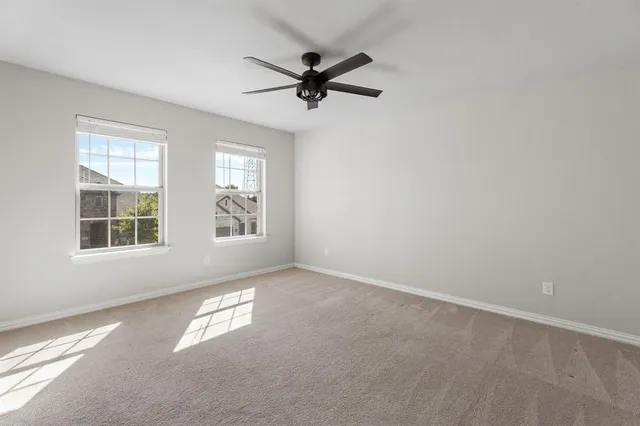 an empty room with windows and fan