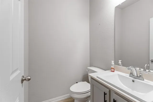 a bathroom with a sink a toilet and a mirror