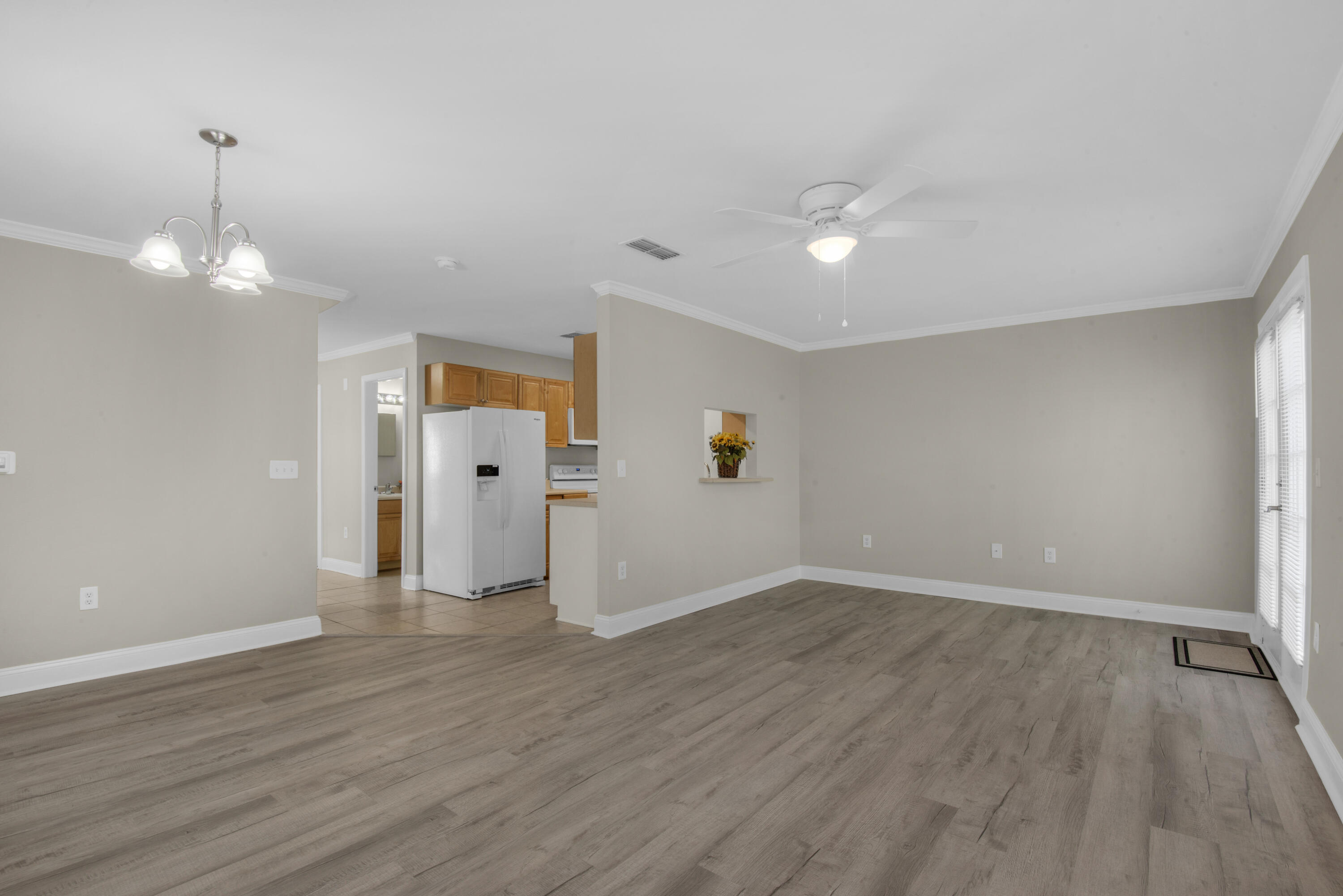 537 Wingspan Way Crestview, FL 32536 - Photo 4 of 34 an empty room with wooden floor and windows