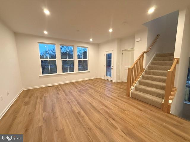 10102 Queens Way Manassas, VA 20110 - Photo 7 of 16 a view of an empty room with wooden floor and stairs