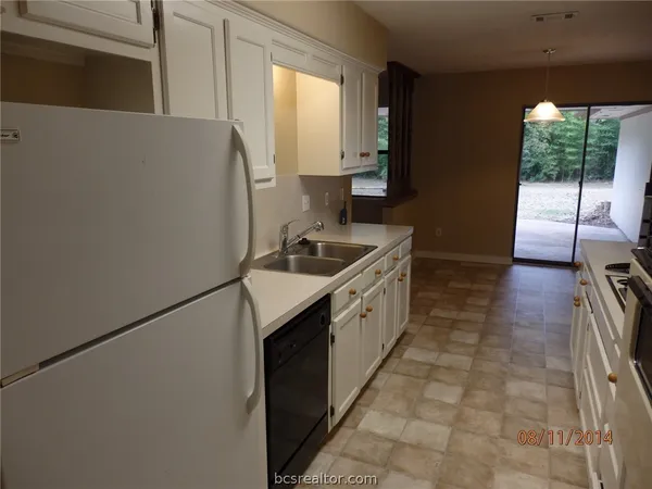 a kitchen with granite countertop a sink stove and cabinets