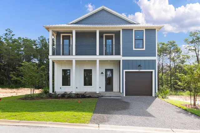 a front view of a house with a garden and yard