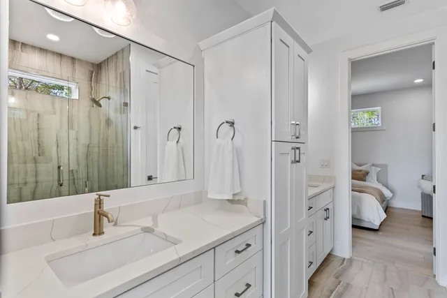 a bathroom with a double vanity sink mirror and shower