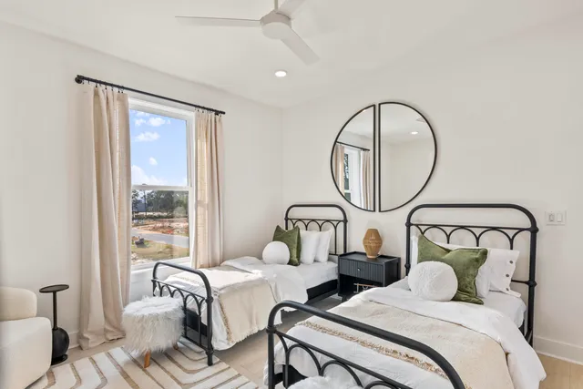 a bedroom with two beds and a large window