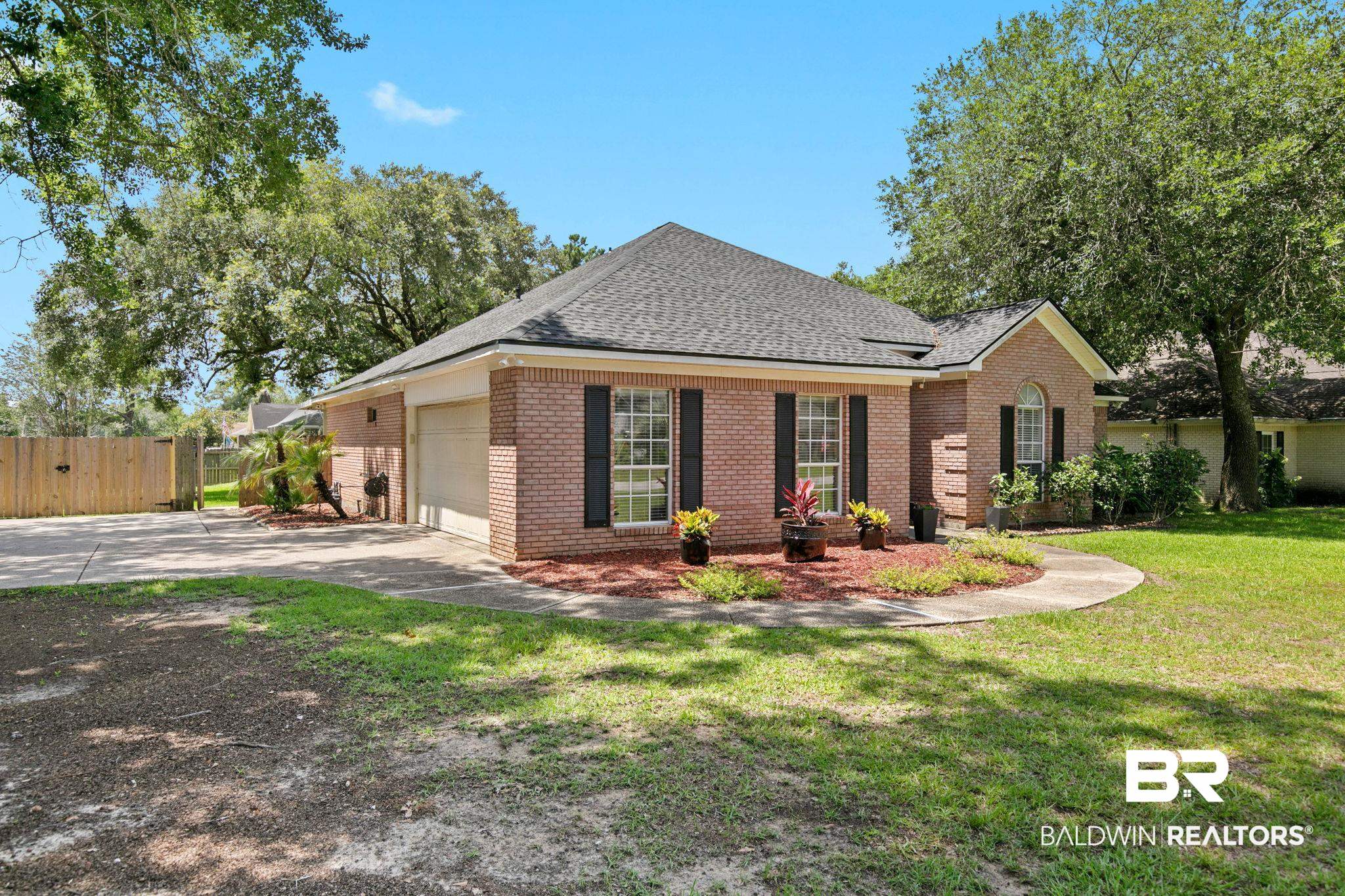 520 Juniper Place Drive Foley, AL 36535 - Photo 2 of 35 Brick exterior with a dark shingle roof and an arched entryway. Fence with Double doors with reinforced metal.