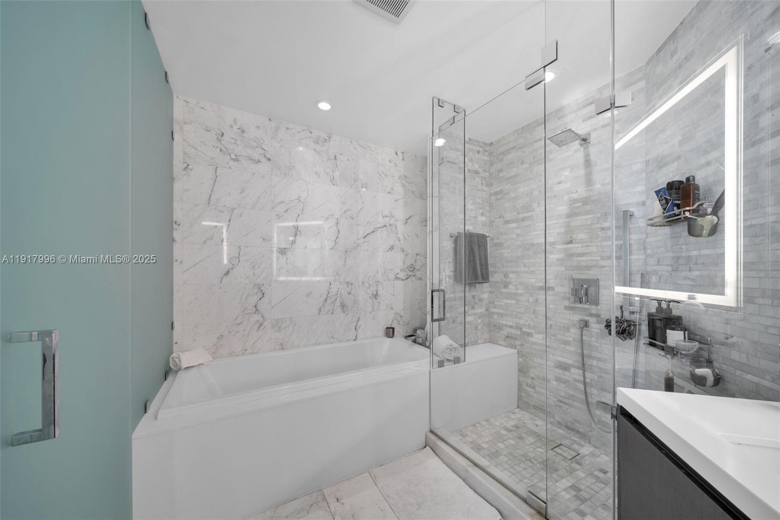 851 Northeast 1st Avenue, Unit 2203 Miami, FL 33132 - Photo 18 of 53 a bathroom with a granite countertop bathtub sink vanity and toilet