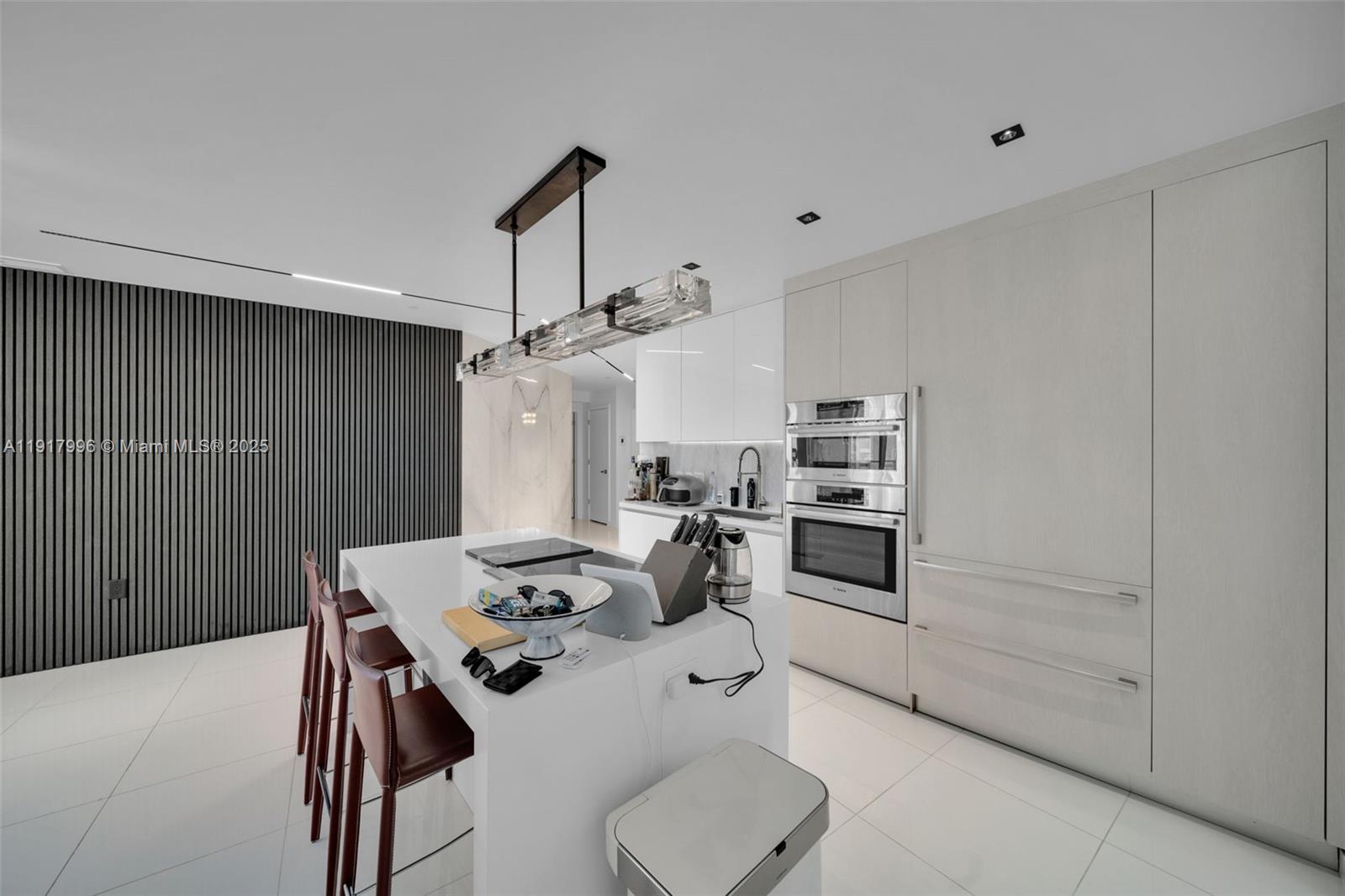 851 Northeast 1st Avenue, Unit 2203 Miami, FL 33132 - Photo 35 of 53 a kitchen with kitchen island a stove a table and chairs in it