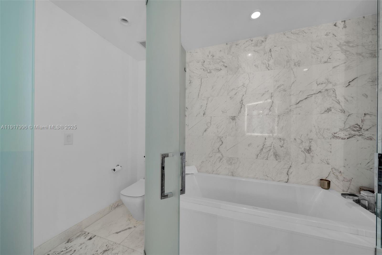 851 Northeast 1st Avenue, Unit 2203 Miami, FL 33132 - Photo 46 of 53 a bathroom with a bathtub and toilet