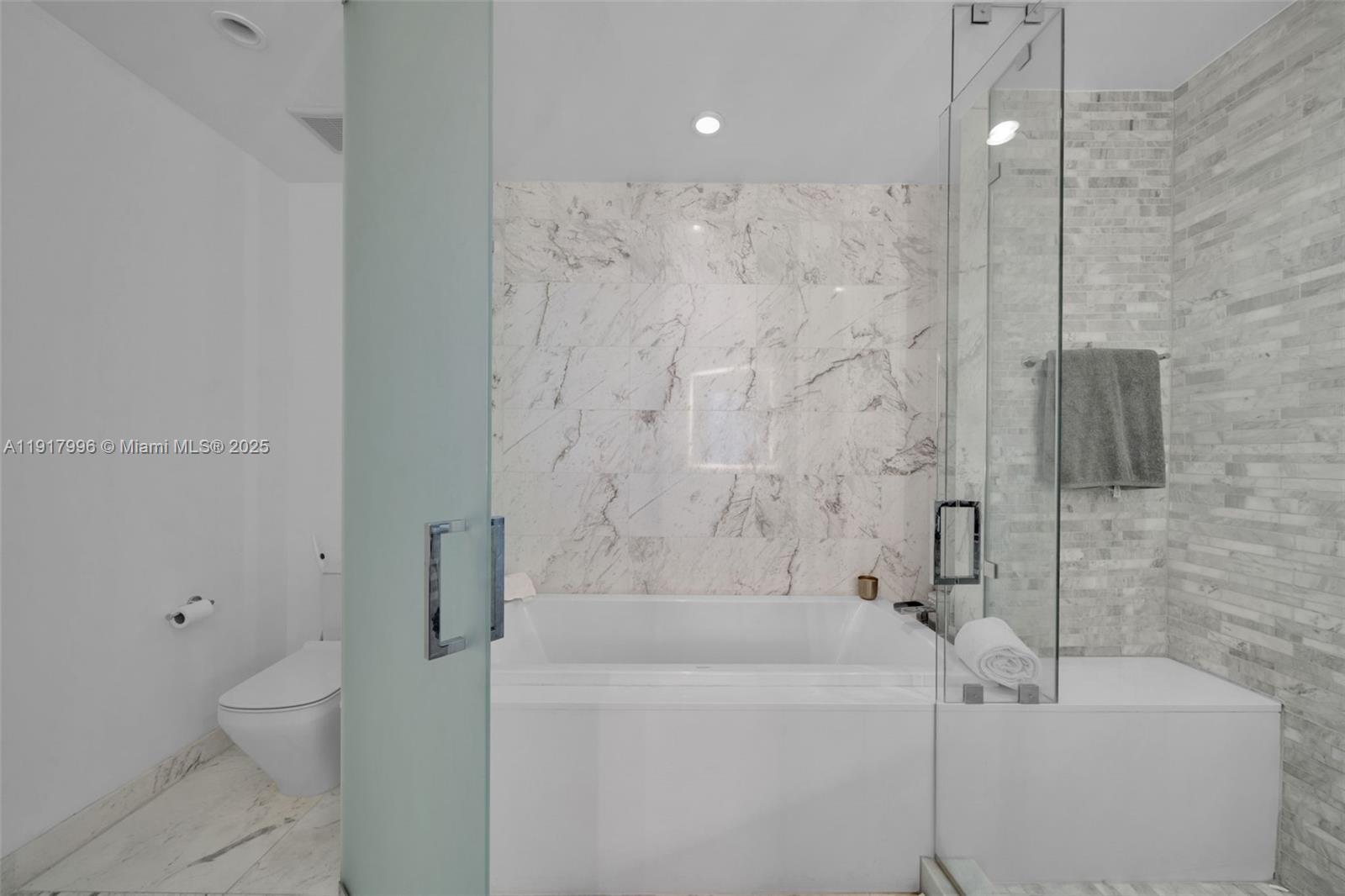 851 Northeast 1st Avenue, Unit 2203 Miami, FL 33132 - Photo 47 of 53 a bathroom with a bathtub a toilet and a shower