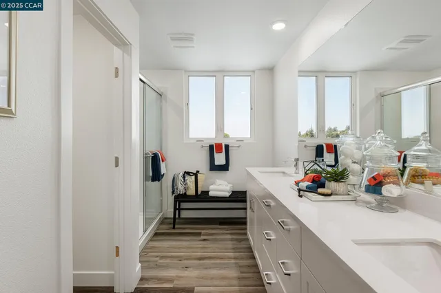 a kitchen with white cabinets and window