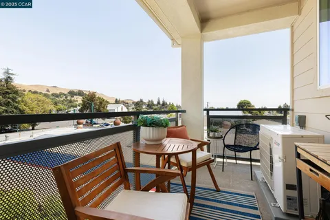 a balcony with table and chairs