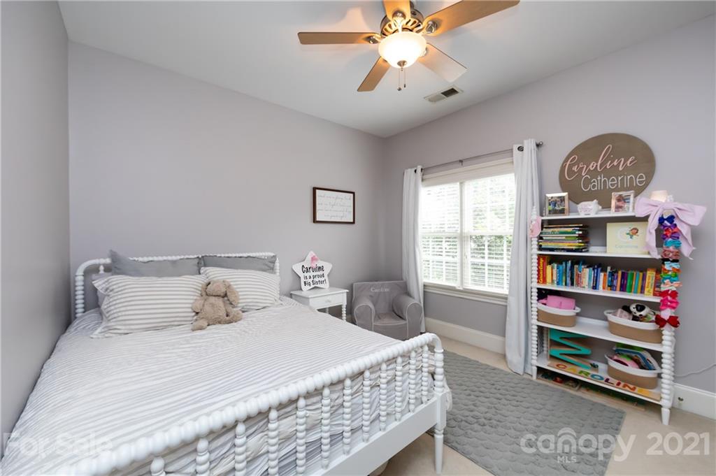 817 Millbrook Road Charlotte, NC 28211 - Photo 17 of 26 a bedroom with a bed a book shelf and a window