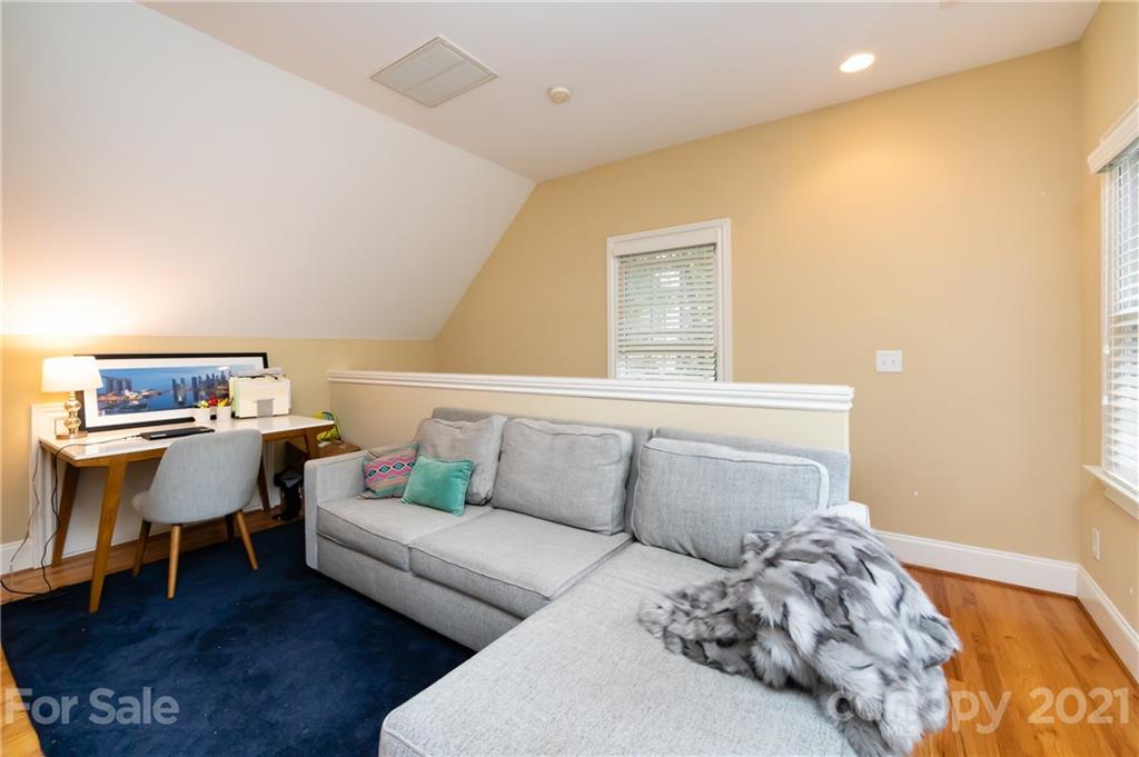 817 Millbrook Road Charlotte, NC 28211 - Photo 23 of 26 a living room with a couch and a dining table with wooden floor