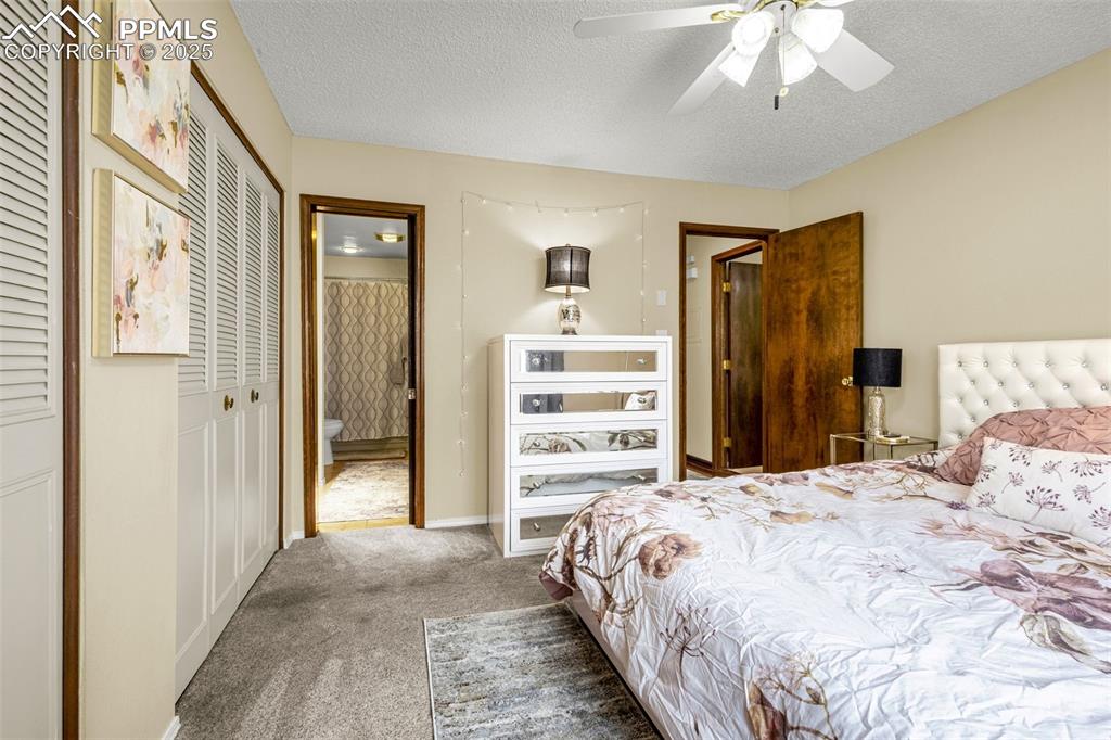 1160 Magic Lamp Way, Unit 4 Monument, CO 80132 - Photo 11 of 23 a bedroom with a bed and a chandelier