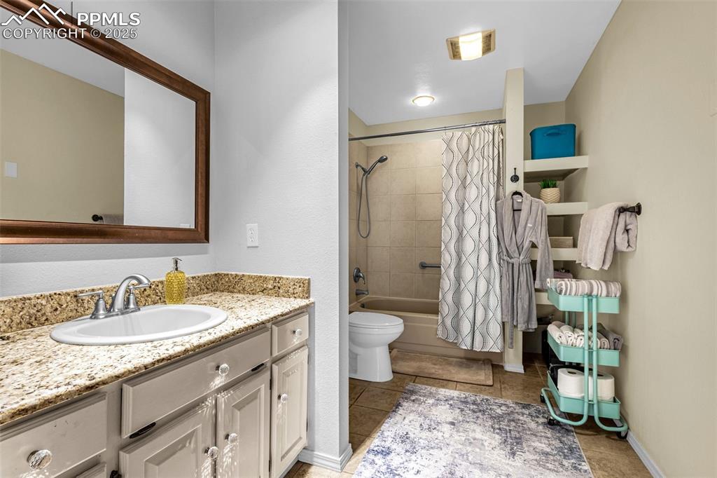 1160 Magic Lamp Way, Unit 4 Monument, CO 80132 - Photo 13 of 23 a bathroom with a granite countertop sink toilet and shower