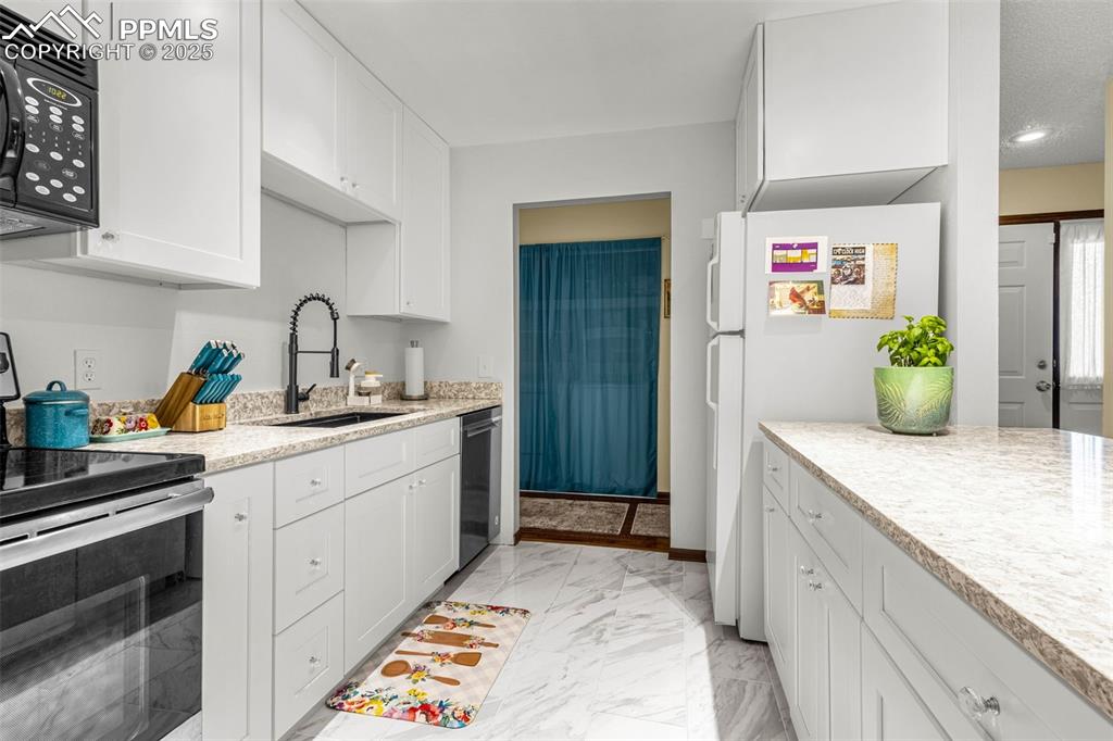 1160 Magic Lamp Way, Unit 4 Monument, CO 80132 - Photo 9 of 23 a kitchen with stainless steel appliances kitchen island granite countertop a sink and cabinets
