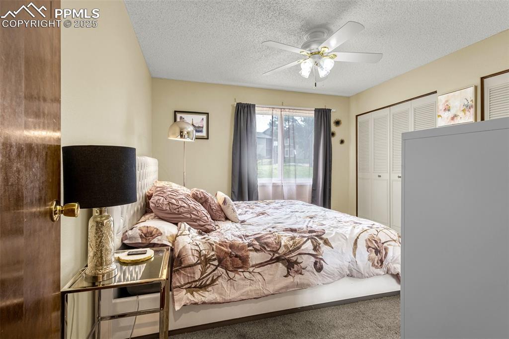 1160 Magic Lamp Way, Unit 4 Monument, CO 80132 - Photo 10 of 23 a bedroom with a bed and a chandelier