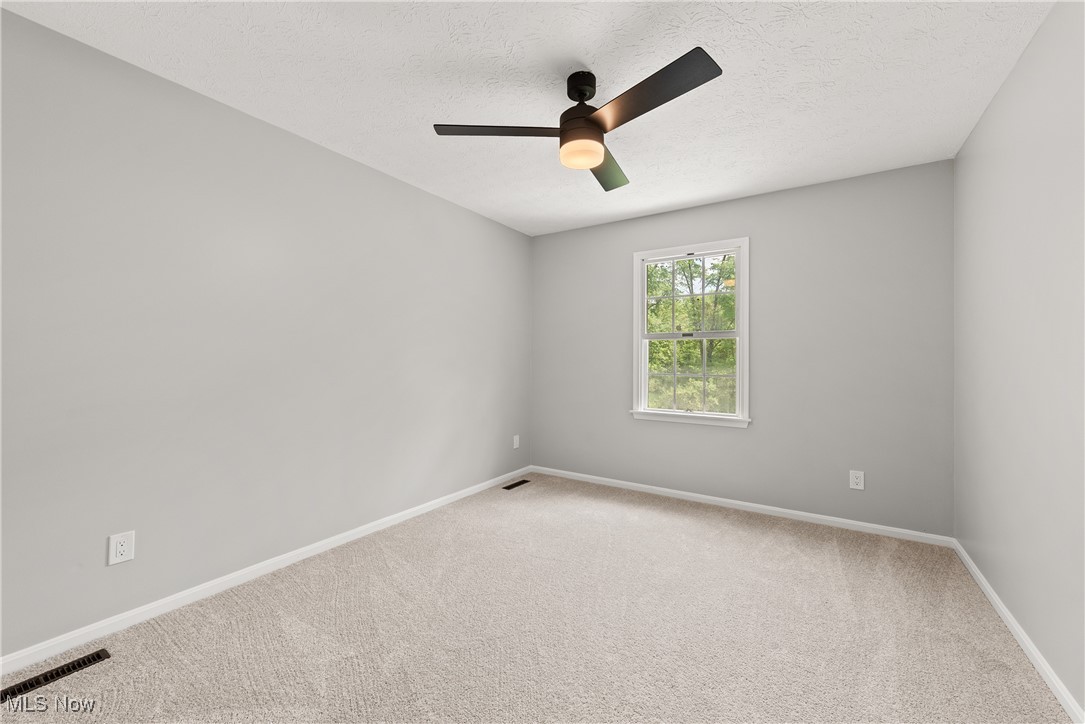 8080 Fair Road Strongsville, OH 44149 - Photo 33 of 50 Carpeted empty room with ceiling fan, baseboards, and a textured ceiling