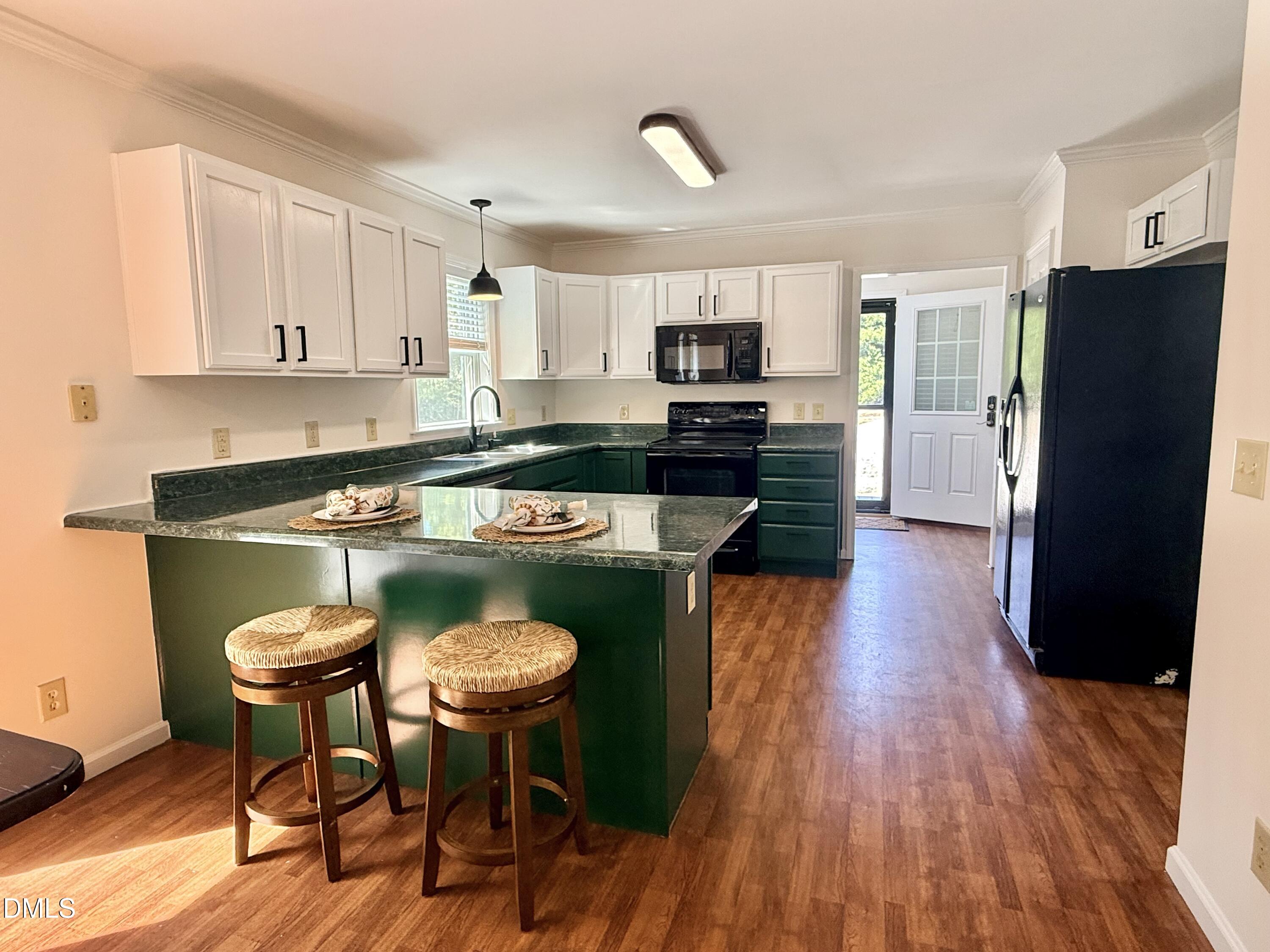 2429 Halifax Road Roxboro, NC 27573 - Photo 16 of 54 a kitchen with stainless steel appliances granite countertop a stove a refrigerator a sink a dining table and chairs with wooden floor