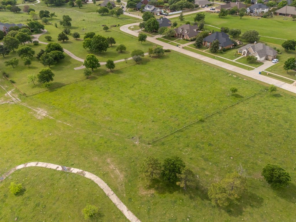 Tbd Sleepy Hollow Road Ennis, TX 75119 - Photo 11 of 11 Expansive green space with a paved pathway, bordered by mature trees and residential properties