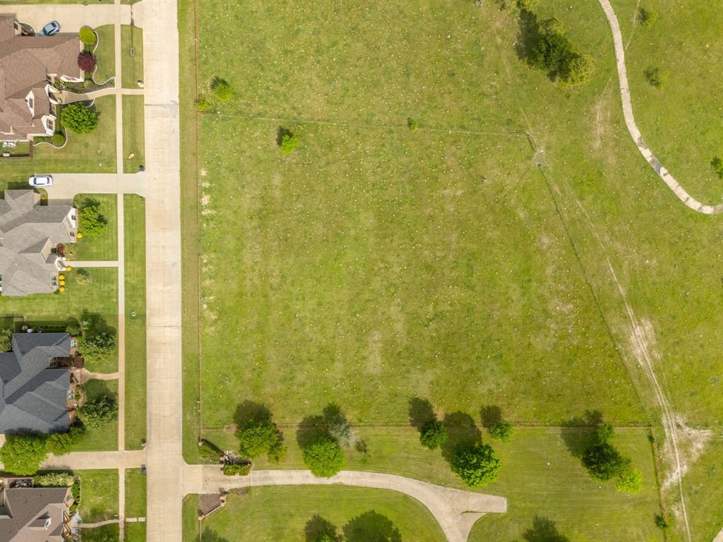 Tbd Sleepy Hollow Road Ennis, TX 75119 - Photo 5 of 11 Aerial view showcasing a substantial grassy lot with scattered trees and a paved path