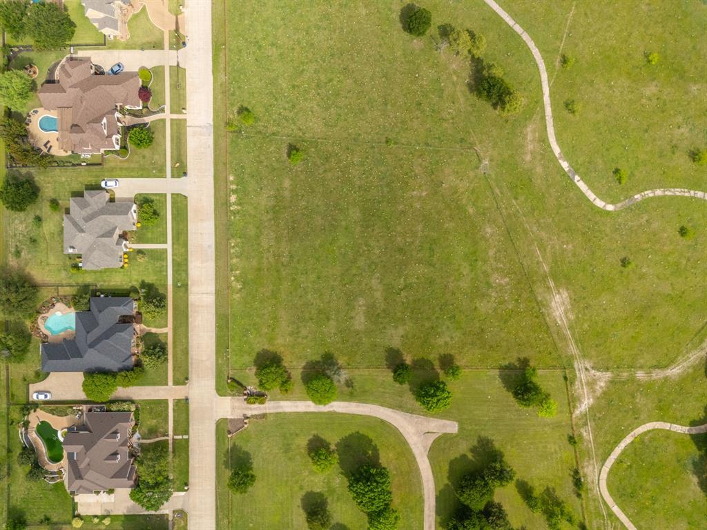 Tbd Sleepy Hollow Road Ennis, TX 75119 - Photo 7 of 11 Aerial view showcasing the expansive green landscape with winding paths, a paved road, and properties featuring private pools