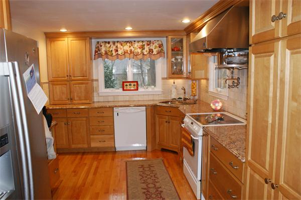 97 Olde Knoll Road Marion, MA 02738 - Photo 3 of 28 a kitchen with stainless steel appliances granite countertop a refrigerator a stove and a sink with wooden cabinets