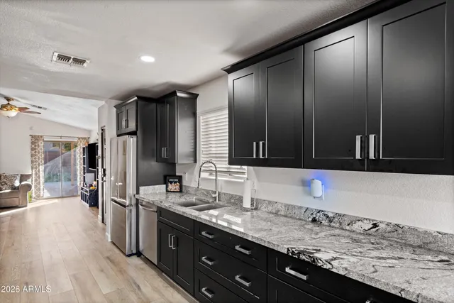 a bathroom with a granite countertop sink and a large mirror