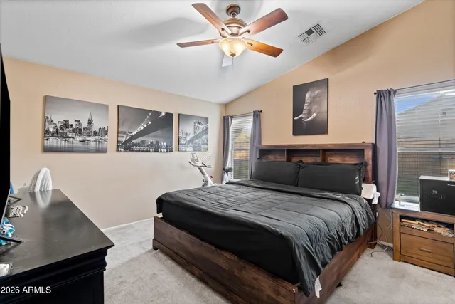 a bedroom with a bed and a desk with stool