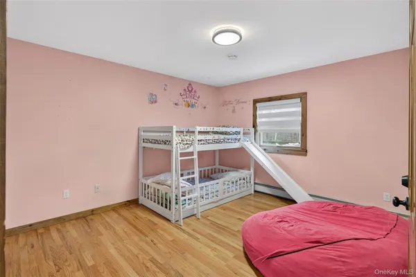 a bedroom with two beds and a wooden floor