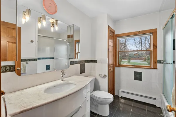 a bathroom with a granite countertop sink mirror vanity and toilet
