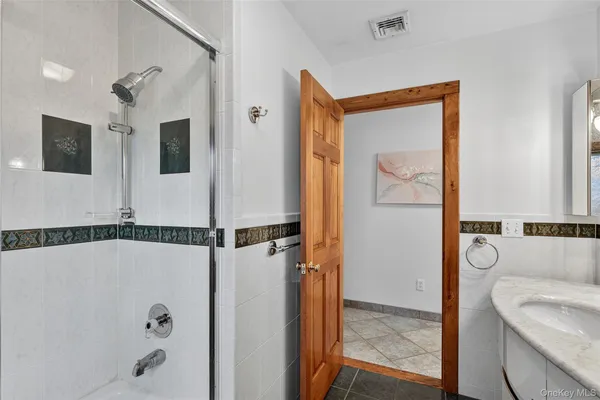 a bathroom with a tub a mirror and a shower