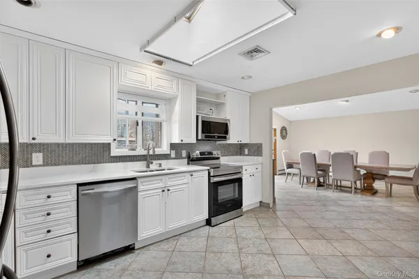 a kitchen with white cabinets and appliances