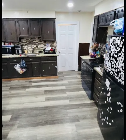 a kitchen with kitchen island granite countertop a stove and a sink